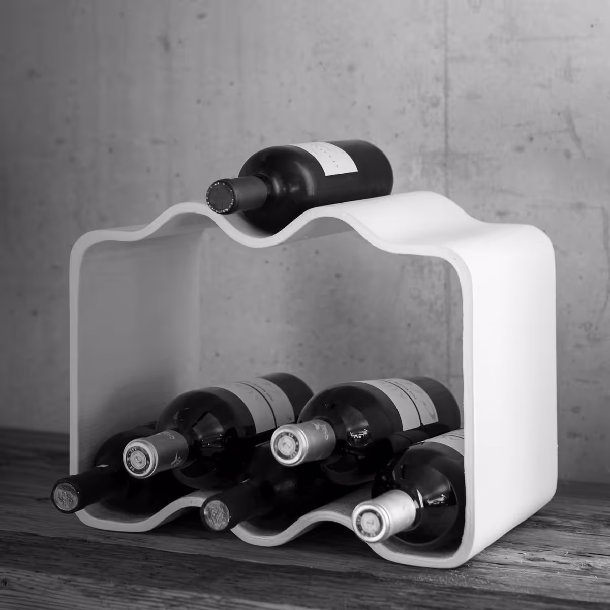 Swisspearl Cheers‑Weinhalter mit Weinflaschen im Inneren.