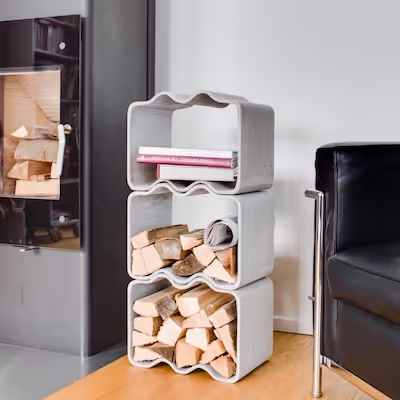 Swisspearl Cheers‑Weinhalter zur Aufbewahrung von Holz neben einem Kamin.