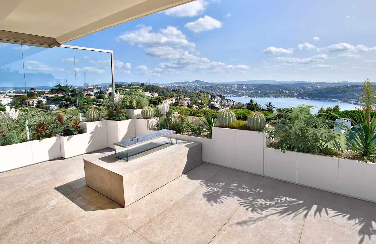 Weiße Domino-Pflanzgefäße auf einer Terrasse mit Blick auf einen See