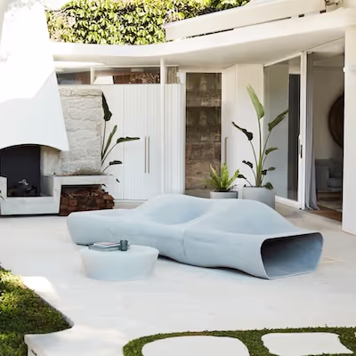 Swisspearl Dune‑Sofa und Porto‑Tisch im modernen Garten neben einem Kamin