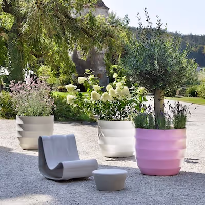 Swisspearl Guhl‑Stuhl, Porto‑Tisch und große rosa sowie weiße Hive Pflanzgefäße im Garten.