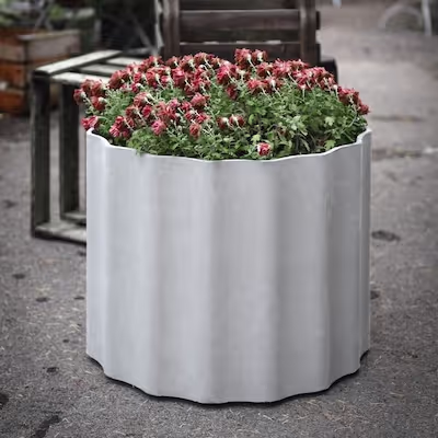 Weißes Swisspearl Kolonna Pflanzgefäß mit Blumen.